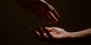Two hands reaching for each other. 