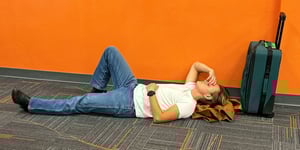 A man lying on the floor with his hand on his face. 