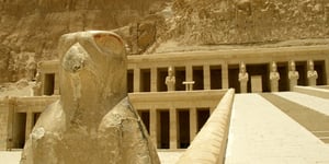 Horus falcon bird statue. Horus is one of the most significant ancient Egyptian deities. The Temple of Hatshepsut is built into a cliff face that rises sharply above it. A turning point in the megalithic geometry of the Old Kingdom. Thebes, Luxor, Egypt.