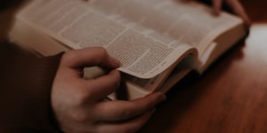 Man holding open a bible. 
