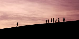 A leader leading a group of people on a mountain. 