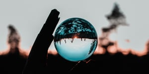 A Glass ball, suspended, showing an introvert sunset landscape. 