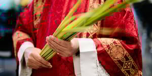 A priest holding a palm leaf.