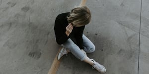 Woman sitting on the pavement. 