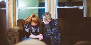 Two women praying together.