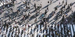 A bunch of people waling on a busy street. 