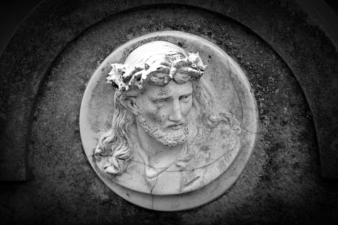 A slate showing a the bust of Jesus with a crown of thorns and a downcast face.