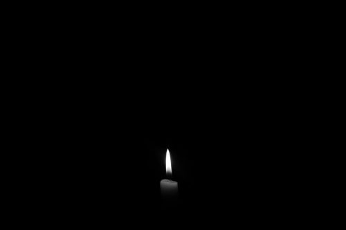 single candle surrounded by darkness