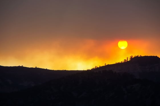 sun sets in sky filled with smoke from wildfires