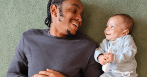 a man smiling at a happy baby