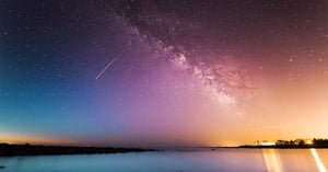 a starry sky over a calm landscape