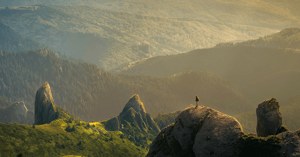 A hiker is gazing at a vast landscape contemplating the meaning of evolution