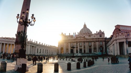 sun rising behind Vatican church cathedral