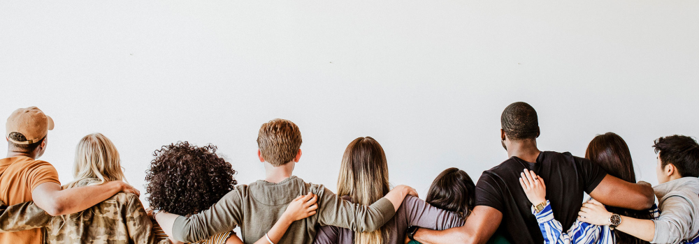 A group of diverse individuals with arms around each other. 