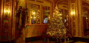 A grand, lit Christian Christmas tree in a foryer. 